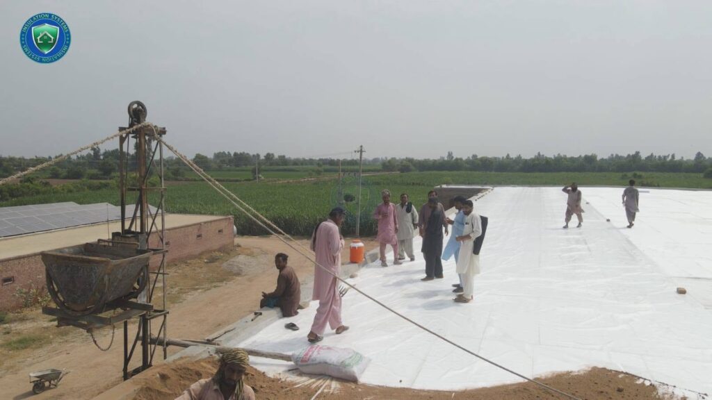 Team of workers installing roof heat proofing insulation on a large shed roof