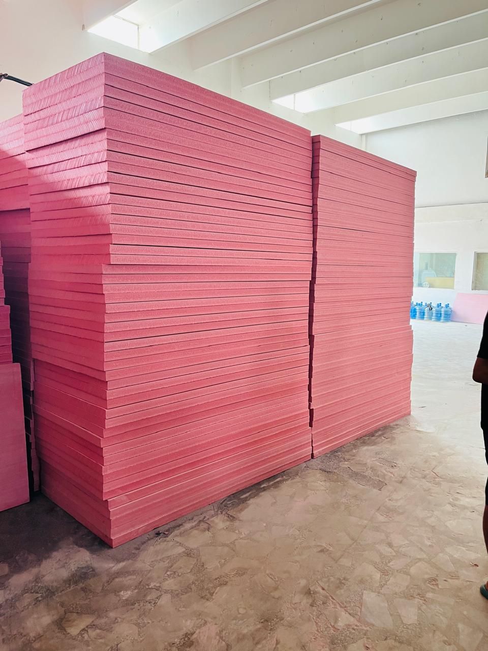 Tall stack of pink Jumbolon XPS sheets in the Insulation System warehouse